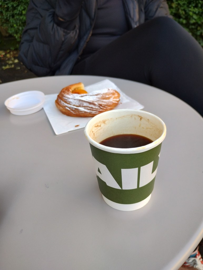 A coffee cup and pastry on a table
